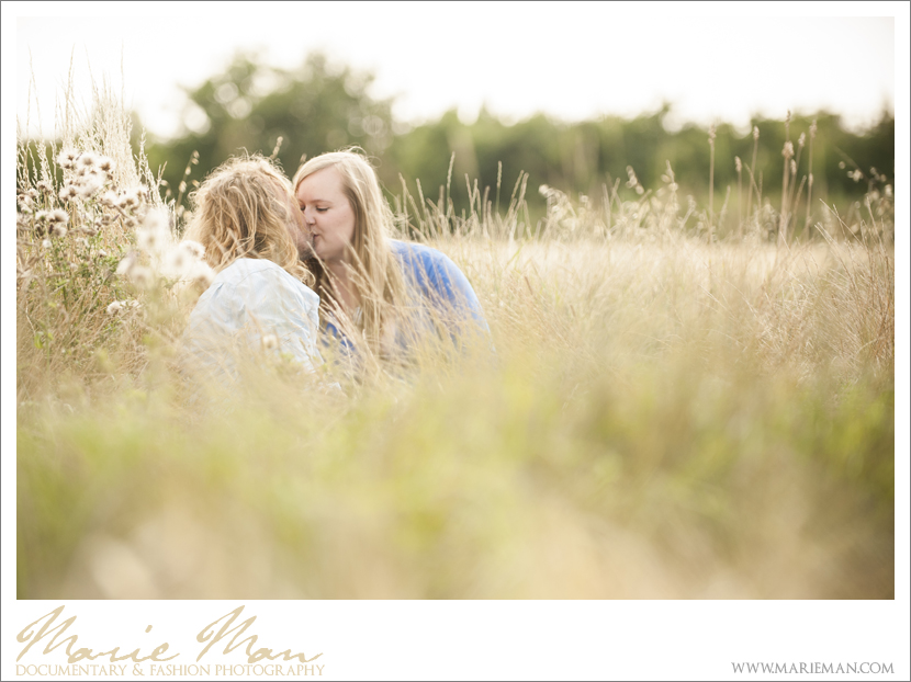 Emily & Paul - couple sitting in a field of grass - Cheltenham Engagement Photography